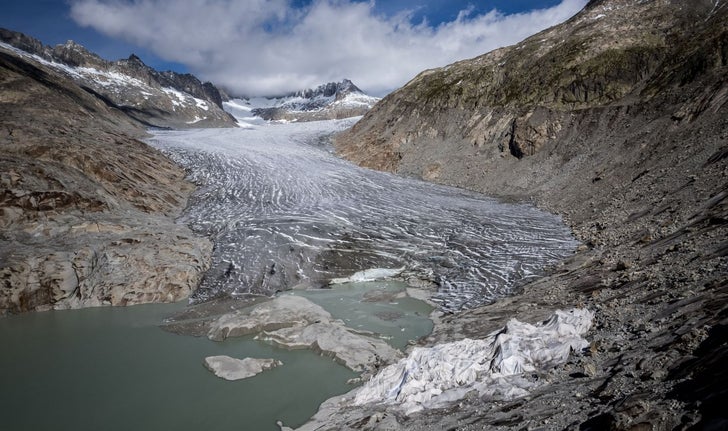 Photo aérienne du glacier du Rhône dont une petite partie est recouverte de mousse isolante pour l’empêcher de fondre, à côté de son lac glaciaire formé par la fonte du glacier due au réchauffement climatique, dans les Alpes suisses, le 30 septembre 2024.